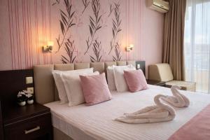 a bedroom with a bed with two swans on it at Hotel Ancora Beach in Primorsko