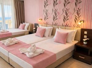 two beds in a hotel room with towels on them at Hotel Ancora Beach in Primorsko