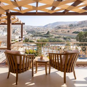 a view from a balcony with two chairs and a table at Petra Guest House Hotel in Petra