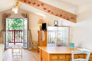 a living room with a wooden table and a window at Chambre d'hôtes d'Émilie in Anglet