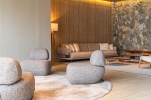 a living room with three chairs and a couch at Hotel Laghetto Pedras Altas in Gramado