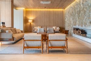 a living room with a couch and a table and chairs at Hotel Laghetto Pedras Altas in Gramado