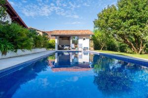 a swimming pool with blue water in front of a house at Chambre d'hôtes d'Émilie in Anglet
