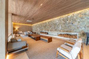 a living room with a large stone wall at Hotel Laghetto Pedras Altas in Gramado