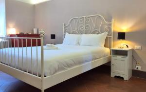 a bedroom with a white bed with white sheets and pillows at Sky Loft La Melissa - Pisa Center in Pisa