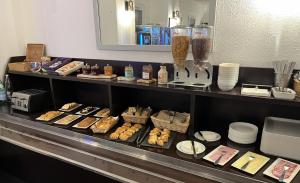 a buffet line with various types of pastries and plates at The Originals Access, Halt'Hotel, Clermont Agnetz in Agnetz