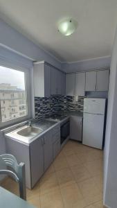 a kitchen with white appliances and a large window at Sea & Sky apartment in Skataj