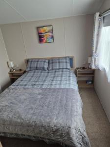 a bed in a bedroom with two nightstands and two tables at Sharmar Eyemouth in Eyemouth