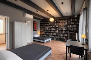 a bedroom with a bed and a desk and bookshelves at Alloggi Nell's in Cornedo Vicentino