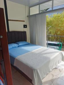 a bedroom with a bed and a large window at Cabaña La Rivera in Macanal