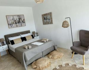 a bedroom with a large bed and a chair at Luxury Villa Vista in Tsouknída