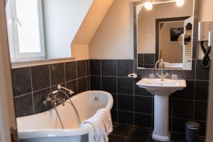 a bathroom with a tub and a sink at Thermae Grimbergen Hotel in Grimbergen +23 photos
