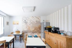 a kitchen with two tables and chairs and a counter at Chambres D'hôtes Madan'hôte in Capbreton