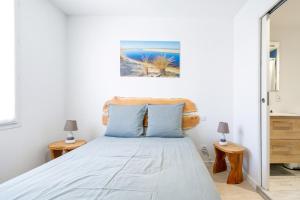 a bedroom with a bed with blue pillows at Chambres D'hôtes Madan'hôte in Capbreton