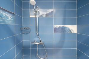 a shower with a shower head in a blue tiled bathroom at Chambres D'hôtes Madan'hôte in Capbreton +44 photos