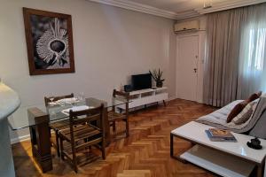 a living room with a table and a couch at Alphaville Serviced Apartment São Paulo in Barueri