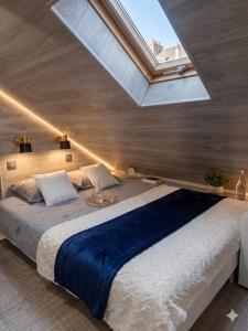 a bedroom with a large bed with a skylight at La'Mansarda in Chişinău