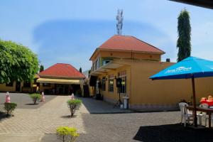 a building with a blue umbrella next to a building at Uhuru 50 Hotel in Kasese