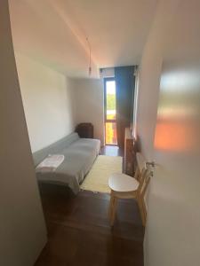 a bedroom with a bed and a chair and a window at Unin Apartman, Kosmaj Renew, Rogača in Rogača
