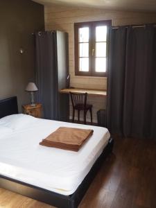 a bedroom with a bed and a table and a window at La Saline in Le Palais
