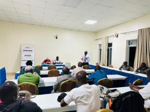 a group of people sitting at tables in a room at Uhuru 50 Hotel in Kasese