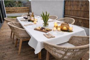 a white table with candles and wine bottles and chairs at Villa des trois singes in Saint-Pierre