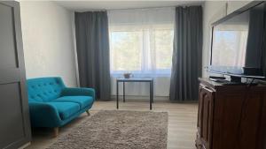 a living room with a blue couch and a television at Raasiku majutus in Raasiku