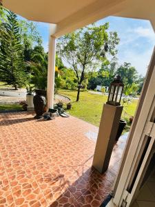 a patio with a brick floor and a view of a yard at Benthota grand villa in Nakandalagoda