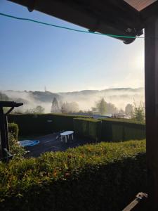 a view from the backyard of a house with a bench at Lilia Chalet in Durbuy