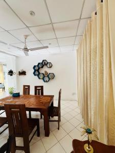 a dining room with a wooden table and chairs at Benthota grand villa in Nakandalagoda