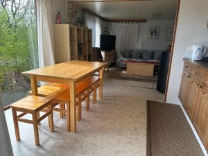 a wooden table and benches in a living room at Lilia Chalet in Durbuy