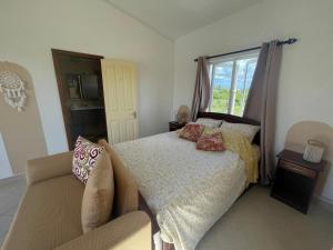 a bedroom with a bed and a couch and a window at Triplex - Suite parentale in Grande Gaube