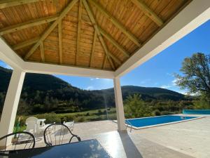an outdoor patio with a pool and a wooden roof at Vila Oaza in Trebinje