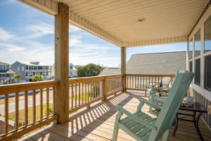 a patio with a table and chairs on a deck at Beach 45 by Oak Island Accommodations in Oak Island