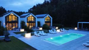 a backyard with a swimming pool and chairs and a house at NOVA ULINIA Forest - dom nad morzem, podgrzewany basen , sauna, balia z jacuzzi, Starlink in Ulinia