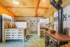 a large kitchen with white cabinets and a stove at Gîte Le Jardin Mirandou in Raucoules +25 photos