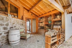 a large room with a barrel and a room with a wooden ceiling at Gîte Le Jardin Mirandou in Raucoules