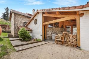 a home with a garage with a lot of wood at Gîte Le Jardin Mirandou in Raucoules