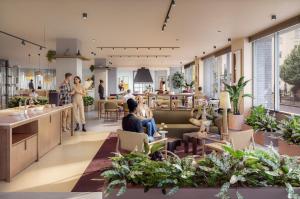 a lobby with people sitting in chairs and plants at ARK Shoreditch in London