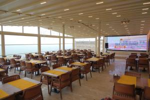 a restaurant with tables and chairs and a projection screen at Helen Olimpos Konağı in Mardin