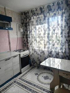 a small kitchen with a stove and a window at 2 кімнатні апартаменти в центрі міста in Pavlohrad