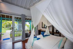 a bedroom with a bed with a mosquito net at Water Blow Huts in Nusa Lembongan +272 photos