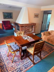 a living room with a table and a fireplace at Rodinný Penzion U Nouzů in Staré Hradiště