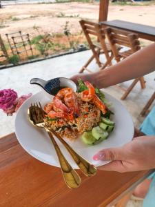 a plate of food with shrimp and vegetables on a table at เดอะมูนไลท์วิลล่าพะเยา in Phayao