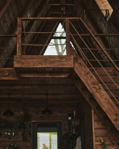 an attic room with a wooden staircase and a window at BRUN Cabin in Şotrile