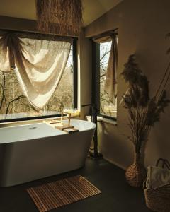 a bathroom with a white tub and a window at BRUN Cabin in Şotrile +20 photos