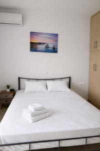a white bed with two white towels on it at Zen Villas in Nikiana +20 photos