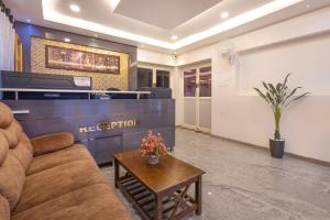 a waiting room with a couch and a table at Cannan Residency Pondicherry in Pūrnānkuppam