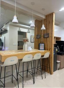 a kitchen with a counter with three stools around it at UrbanGem Iloilo in Iloilo City