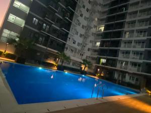 a swimming pool in front of a building at night at UrbanGem Iloilo in Iloilo City +6 photos